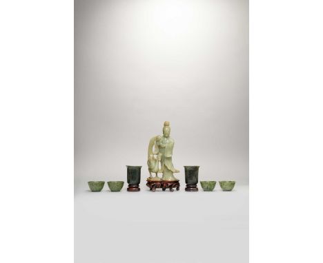 SIX CHINESE SPINACH-GREEN JADE CUPS AND A BOWENITE FIGURELATE QING DYNASTYComprising: two U-shaped cups with flared rims, fou