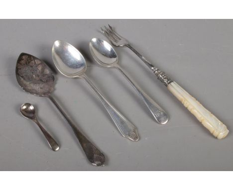 A small quantity of silver. Includes silver spoons, silver pickle fork with mother of pearl handle, etc. Gross weight 105g.  