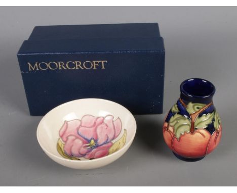 Two pieces of Moorcroft pottery include Apples pedestal vase (boxed) and small magnolia white ground bowl.  