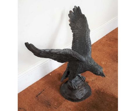 A WELL CAST LIFE SIZE METAL MODEL EAGLE with wings spread perched upon a rock, 75cm high (to tip of the wing) 