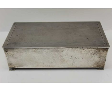 ALFRED DEELEY, A SILVER CIGARETTE BOX, engine turned hinged cover, raised on bracket feet, wooden lined, Birmingham 1936, wei