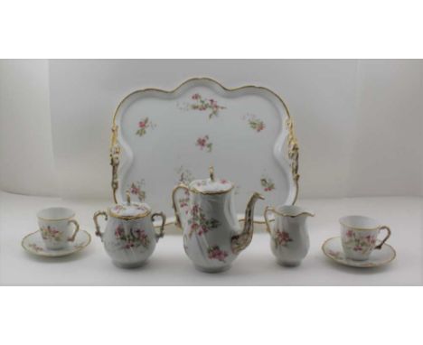 A LIMOGES PORCELAIN CABARET TEA SET, comprising; two-handled tray, 36cm x 32cm, a teapot with cover, sucrier with cover, milk