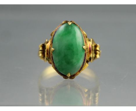 YELLOW METAL RING set with an oval polished jade cabochon stone 10 x 8mm.  Ring size L.(B.P. 24% incl. VAT)