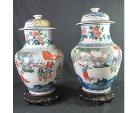 TWO SIMILAR CHINESE PORCELAIN, BALUSTER SHAPED, LIDDED VASES in transitional Wucai style.  Both decorated in enamel palette w