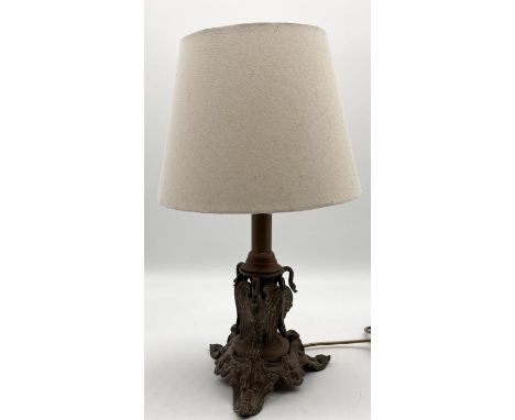 A turn of the century brass lamp, supported by three swans