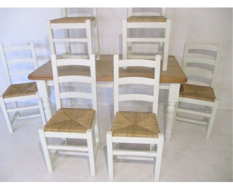 A part painted farmhouse pine table with six ladder-back chairs with twisted reed seats.