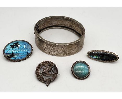 A Sterling silver hinged bangle along with four silver brooches