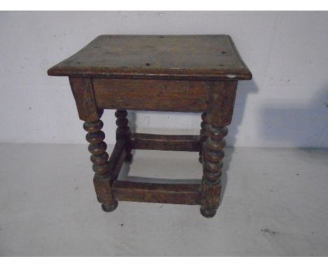 An antique oak bobbin turned stool 