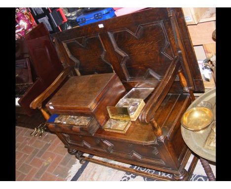 A carved oak monks bench
