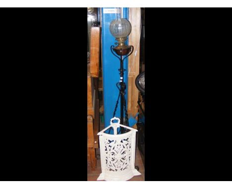 An oil lamp on wrought iron stand together with cast iron stick stand