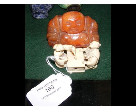 A carved ivory Netsuke with Japanese couple having tea, together with a carved jade? buddha CONDITION REPORTWe have attached 