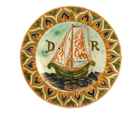 Ruth Bare for Della Robbia, an art pottery plate, the centre sgraffito decorated with a ship in sail and D R, within a floral