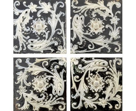 Martin Brothers, a stoneware four tile panel, circa 1880, relief moulded with rosettes and foliate scroll motifs, each tile 7