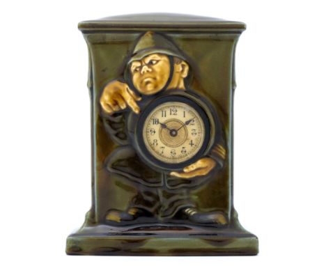 Charles Noke for Royal Doulton, a green Kingsware clock, plinth form, relief moulded with a policeman holding a dial, printed