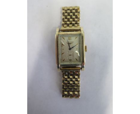 A 14ct yellow gold manual wind Longines wristwatch 25mm wide, including button, on a 9ct yellow gold strap, some spotting to 