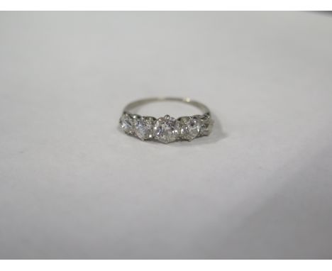 A five stone diamond ring, largest stone approx 0.45ct, approx 2.2 grams, on an unmarked white metal band, size K - some wear