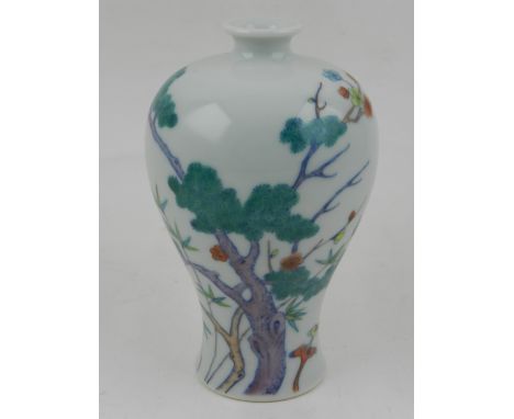 A Chinese doucai style porcelain baluster vase, decorated with blossoming flowers, bears seal mark to base. H.14cm