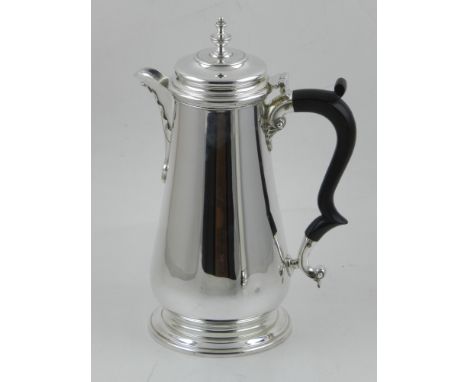 A Queen Anne style silver coffee pot, with plain tapering body, scroll handle and hinged lid with urn finial, hallmarked Lond