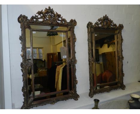 A pair of Louis XV style pier mirrors, with carved and pierced decorated border and finial. H.92cm W.55cm