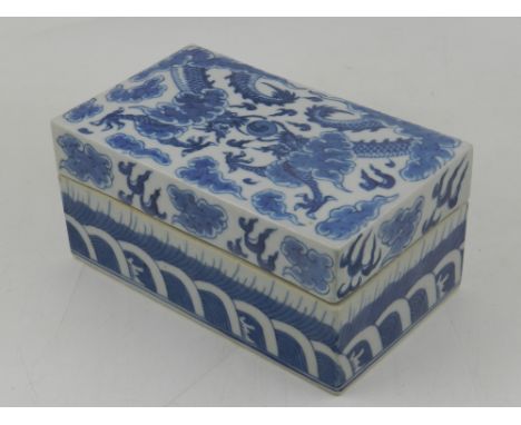 A 19th century Chinese blue and white porcelain box and cover, decorated with twin four clawed dragons chasing a flaming pear