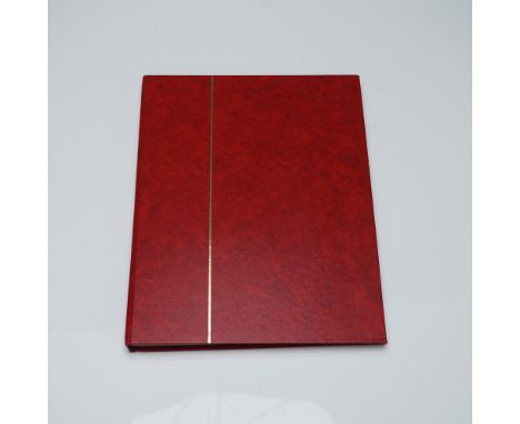 Red stamp album marked Made in Hungary, containing a 9-page curated selection of postage stamps, primarily from the United St