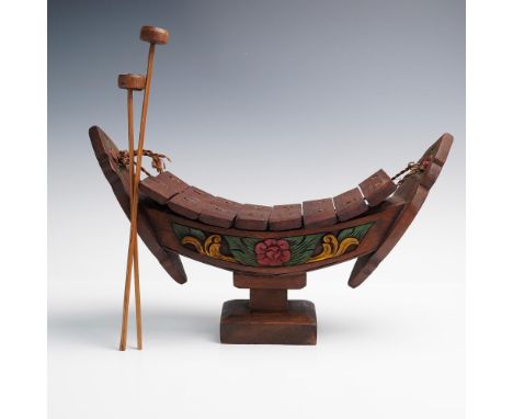 Celebrate the beauty of traditional craftsmanship with this striking hand-carved wooden xylophone, designed in the shape of a