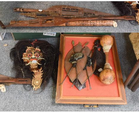 A Collection of Tribal Art, including African hardwood paddle clubs, South East Asian portrait plaques and a Balanese polychr