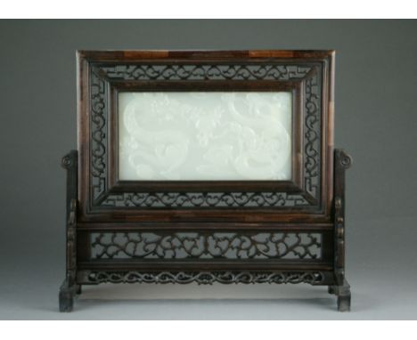 A near white celadon jade and hardwood table screen, 20th Century, of rectangular form, the panel carved with two dragons cha