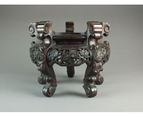 A large Chinese carved hardwood vase stand, late Qing Dynasty, the circular top raised on five scroll supports carved with fl