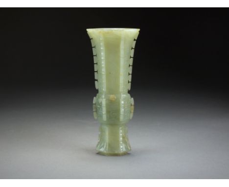 A Chinese celadon jade archaistic beaker vase, Gu, late Qing Dynasty, of compressed hexagonal section, incised with taoist sy