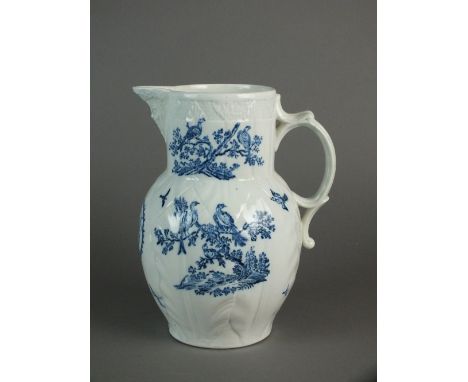 A Caughley mask-head jug printed in the Birds in the Branches pattern, circa 1782-90, the blue and white pattern including a 