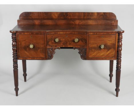 A William IV mahogany sideboard the low shelf back over a concave central short drawer flanked by a cockbeaded deep drawer to