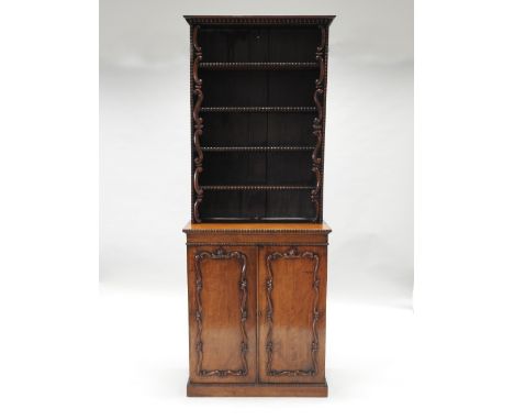 A mid 19th century mahogany cabinet bookcase, of narrow slender form, the bookcase top with half bobbin turned mouldings and 