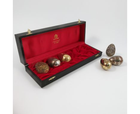 A boxed set of six Stuart Devlin silver and silver gilt eggs, each one with a different textured, engraved or pierced finish,