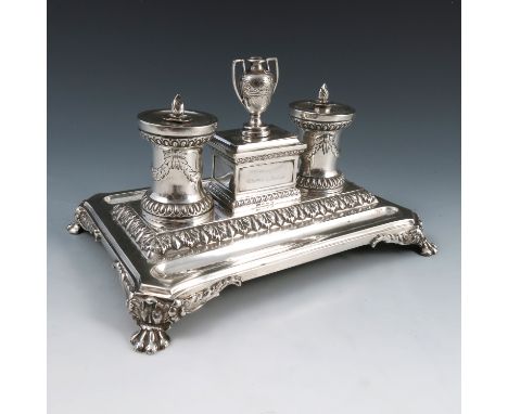 A Victorian silver desk stand, of rectangular form, having two pen wells, the centre with a covered box with urn finial flank