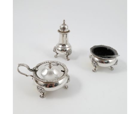 A silver three piece condiment set, with gadrooned edge and raised on lion mask and scroll legs, Birmingham 1974, maker Garra