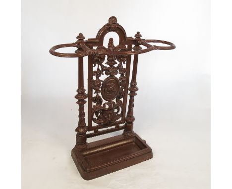 A Coalbrookdale style wrought iron stick stand, decorated with floral swags and masks, painted brown, height 29ins