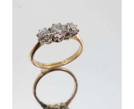 A three stone diamond ring, stamped 'Fine Plat' and '18ct', the graduated old brilliant cuts totalling approximately 0.85 car