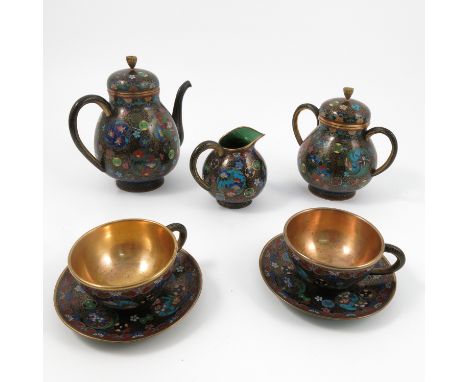 A cloisonne tea set, comprising tea pot, two handled covered sugar bowl, milk jug, two cups and two saucers, all decorated wi