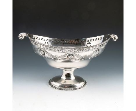 A large silver oval pedestal bowl, having a pair of scroll handles, the shaped body pierced and engraved with Classical urns,