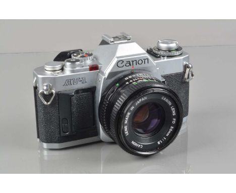 A Canon AV-1 SLR Camera, chrome, shutter working, meter responsive, self timer working, body G, with50mm f/1.8 FD lens, barre