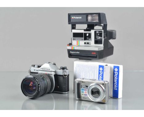 A Pentax K1000 SLR Camera, shutter working, meter responsive, body G, with Pentax A 28-80mm f/3.5-4.5 lens, G, with a Polaroi