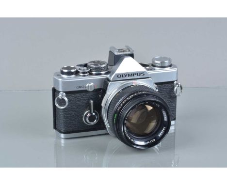 An Olympus OM-2n SLR Camera, shutter slow on one second, responsive in auto, body G, some paint wear to back, with G Zuiko Au