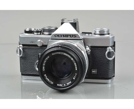 An Olympus OM-2 SLR Camera, shutter working, meter responsive, responsive in auto, self timer working, body G-VG, light wear,