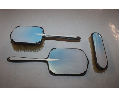 A Chester silver and enamel decorated dressing table hand mirror and two brushes by Walker & Hall 