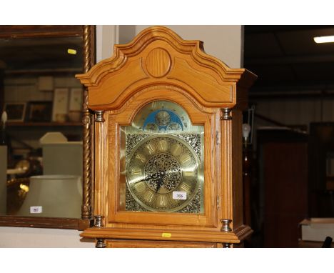 A modern pine longcase clock with brass dial, visual pendulum and weights 