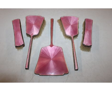 A Birmingham silver and pink enamel dressing table hand mirror and four brushes, by Lanson Ltd.