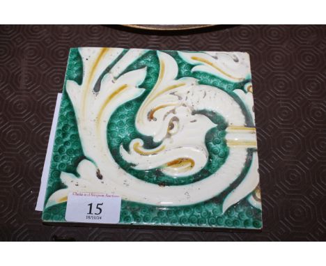 A ceramic tile with serpent decoration