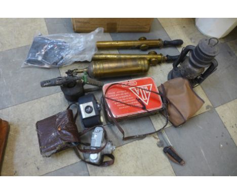 A box of assorted items, including a stirrup pumps, a Tilley lamp, etc. 