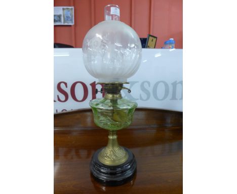 A Victorian brass oil lamp, with green glass reservoir 